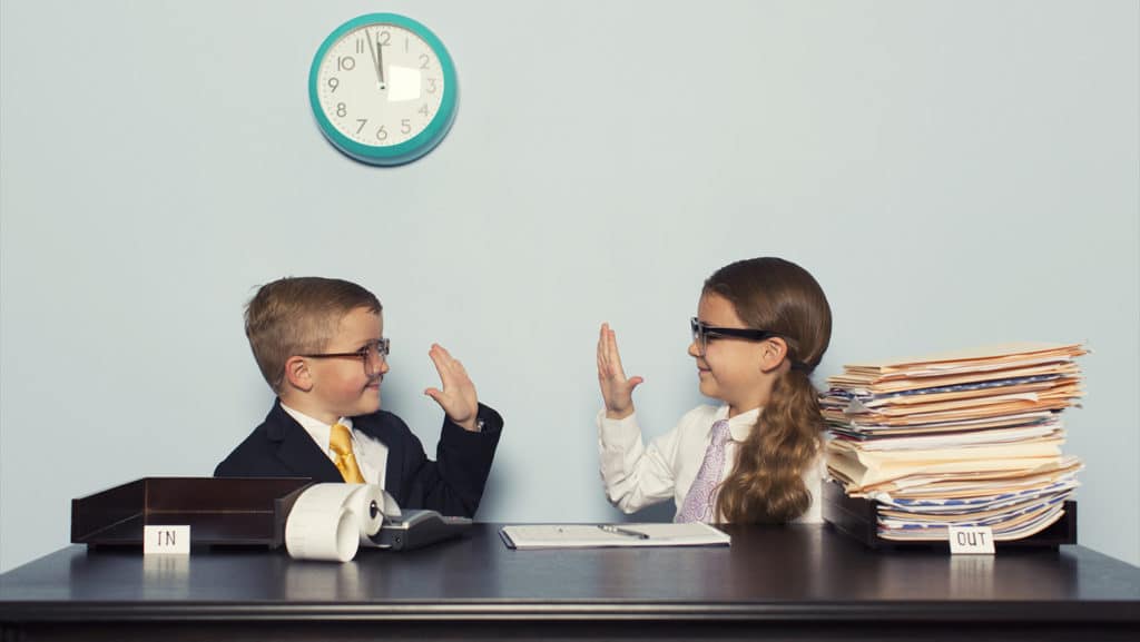 two kids dressed in business attire about to give a high five